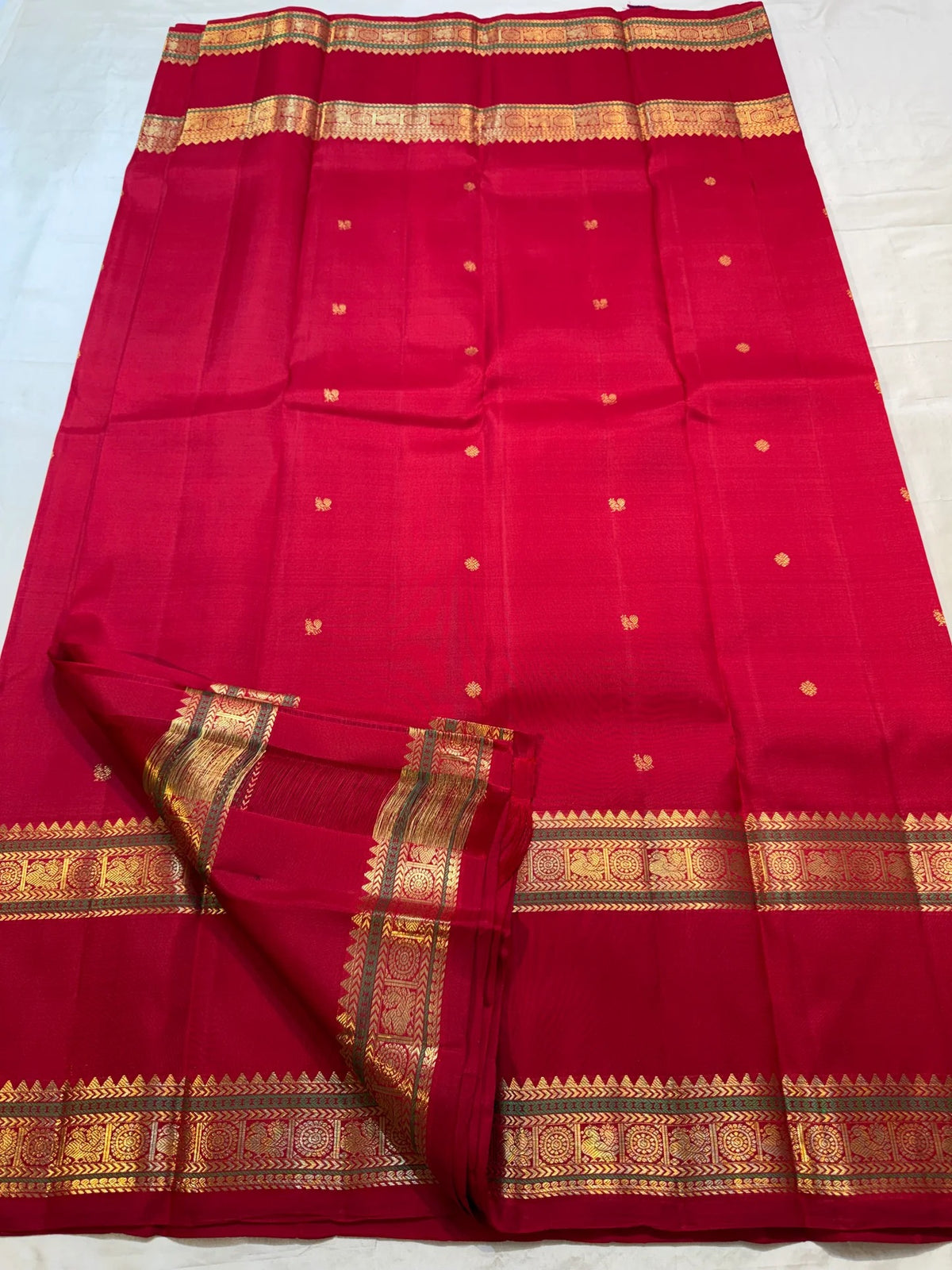 Vermilion Red Kanjeevaram saree body with small individual gold zari buttas.