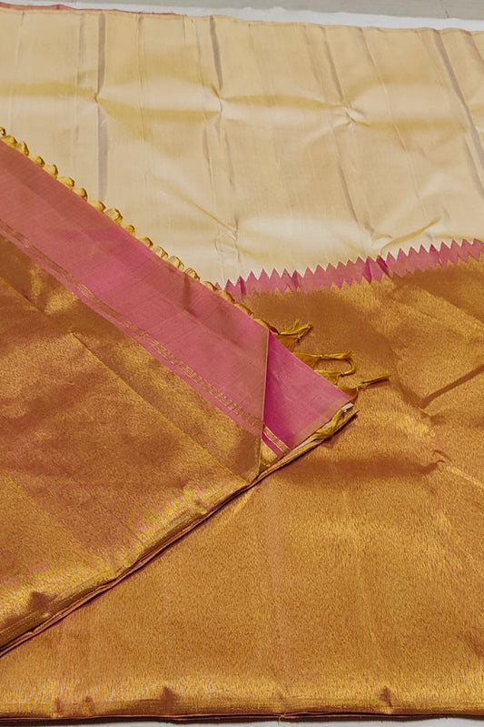 Warm Ivory pure mulberry silk saree with expansive antique-gold Ettukol border.