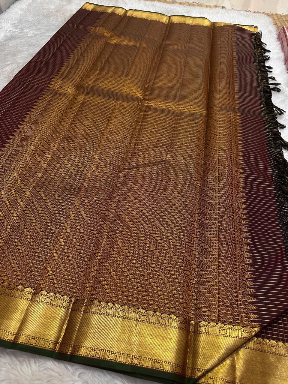 Close-up of burgundy deep coffee brown silk body showing luminous Zari Kattam gold grid on thick-ply pure mulberry silk