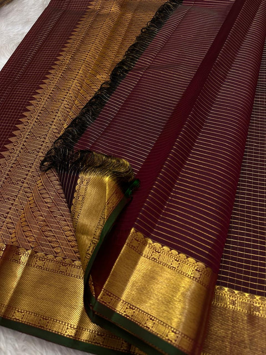 Thick antique gold zari woven border with floral and geometric motifs on burgundy deep coffee brown Kanjeevaram saree
