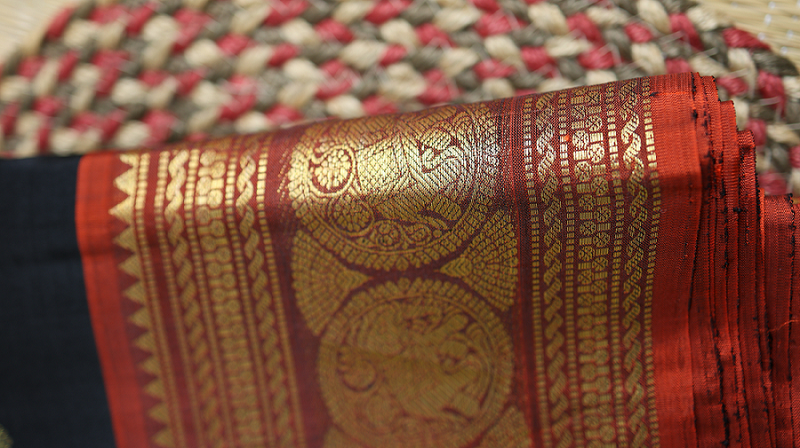 Black Kanchipuram silk saree with red gold zari border and traditional motifs