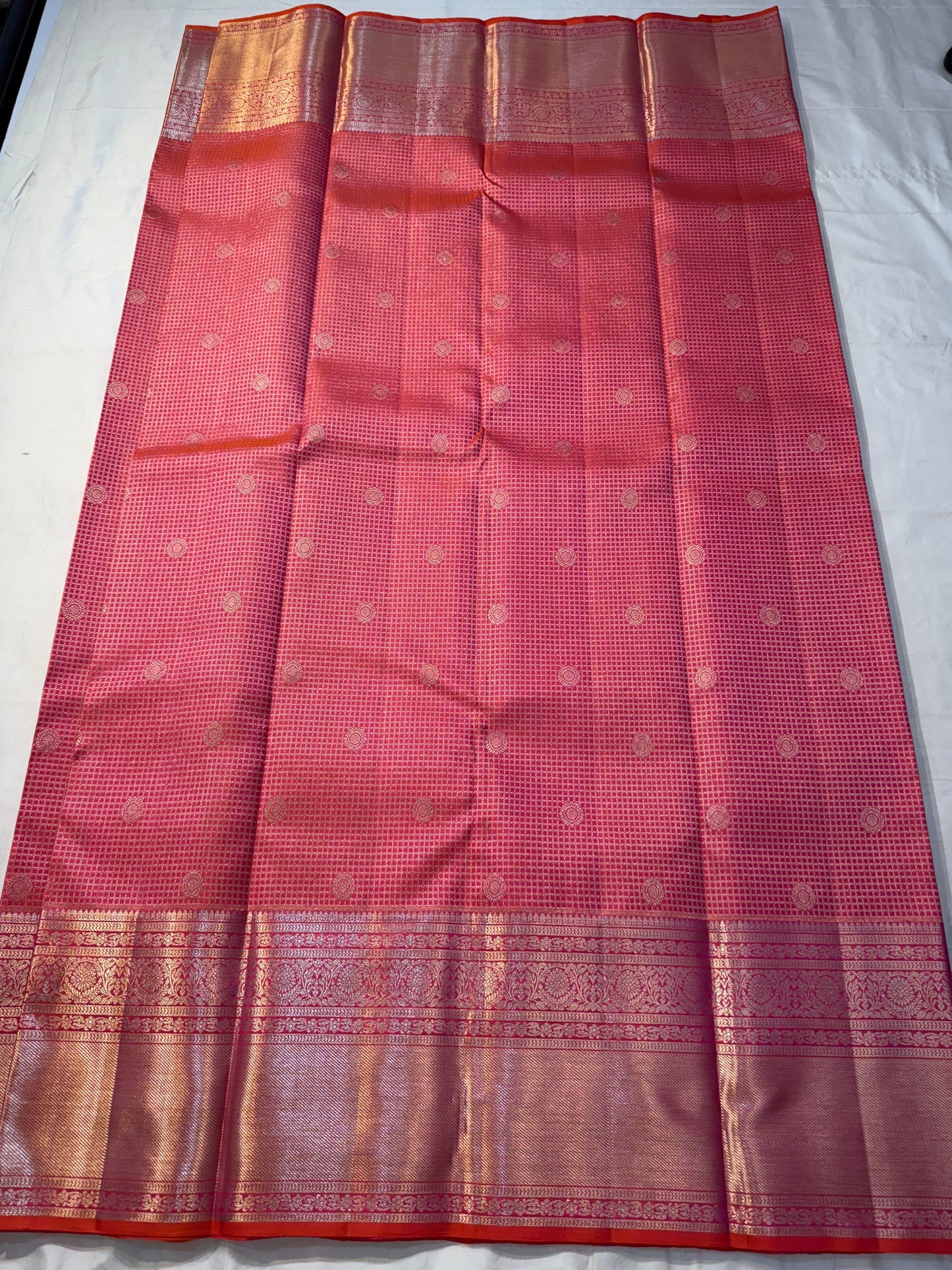 Peach Pink Flower Butta – Coral-pink shot body with micro checks & floral buttas

Handwoven Kanchipuram silk with delicate copper-pink zari work

Elegant floral vines on borders • grand rose-gold brocade pallu

Silk Mark Certified | Fall & Pico Done |