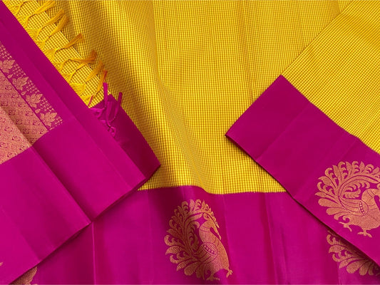 Kanakambari — Pure Kanchipuram Silk Saree (Haldi Yellow × Rani Magenta)
Vibrant haldi-yellow micro-checked body with antique zari peacock motifs on korvai magenta borders
Silk Mark Certified • Fall & Pico Done • Blouse Stitching Available ($30) • Free Shi