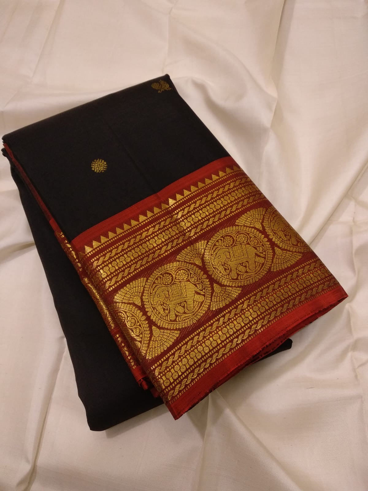 Intricate gold zari pallu detail on black Kanchipuram saree