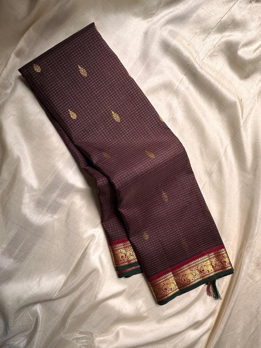 Close view of traditional gold zari elephant border on brown Kanchipuram saree