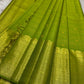 A radiant parrot green Kanchipuram silk saree that dazzles. The body features a delicate grid-like zari weave with small gold buttas scattered. The rich gold zari pallu stands out with grand temple-inspired arches and intricate motifs.