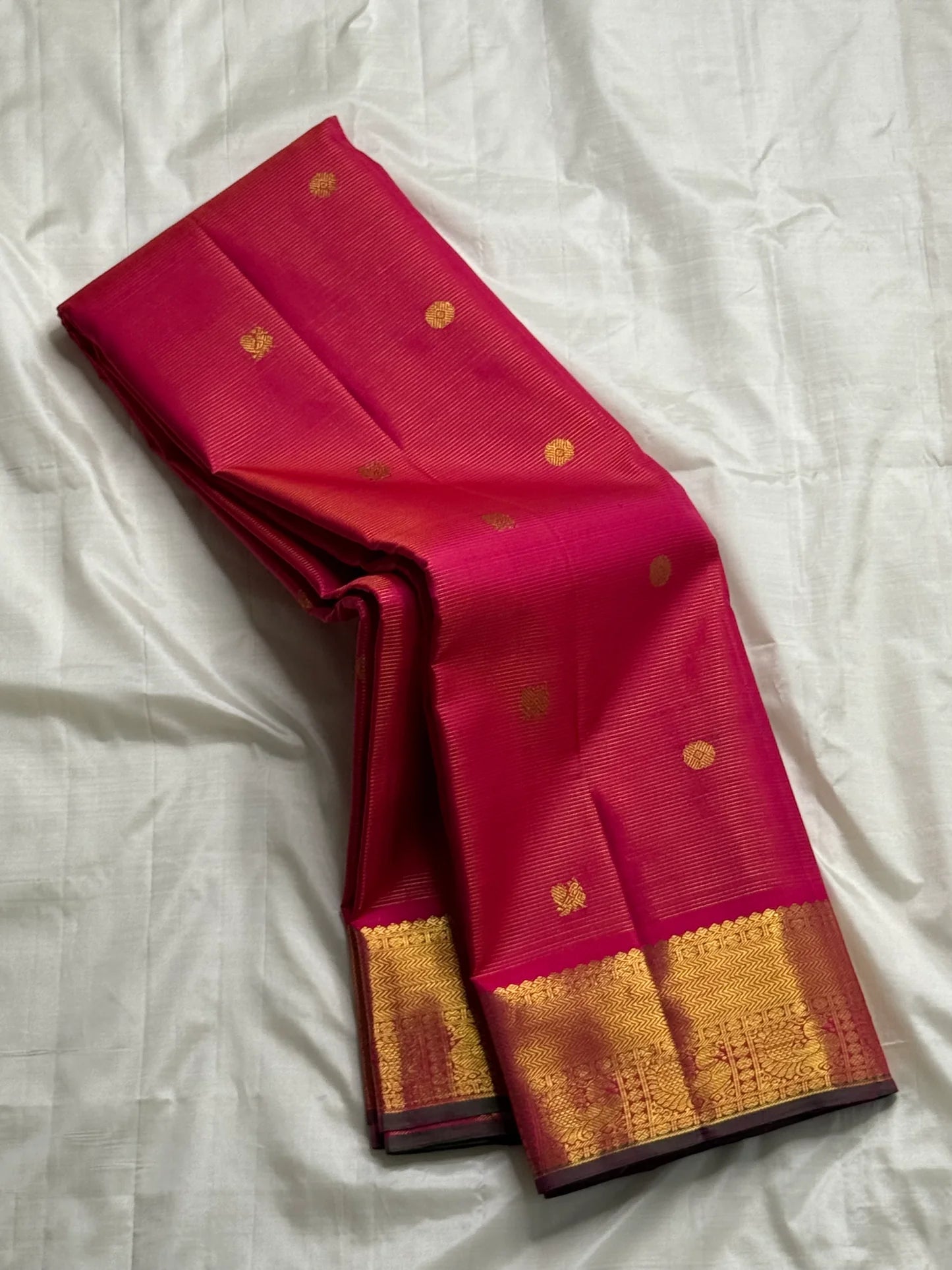 Vairaoosi Rani Mayil Chakram — Pure Kanchipuram Silk Saree
Rani-pink body with gold chakram buttas & korvai mayil zari border in dark green selvedge ✨
Silk Mark Certified • Free Shipping within USA • Ships in Two Weeks