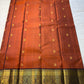 Rust Orange Supreme – Korvai Kanchipuram Pure Silk Saree
Shot rust-orange body with gold chakram & mankolam buttas all over
Deep purple korvai border with annam & chakram zari medallions
Rich vadamalli zari-brocade pallu | Contrast blouse | Fall & Pico Do