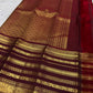 Dark Arakku pallu densely woven with gold geometric and floral zari on a turmeric yellow Kanchipuram saree
