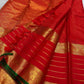 Open view of red Kanchipuram silk saree with tasselled pallu, horizontal gold zari lines and ornate elephant border with green selvedge.