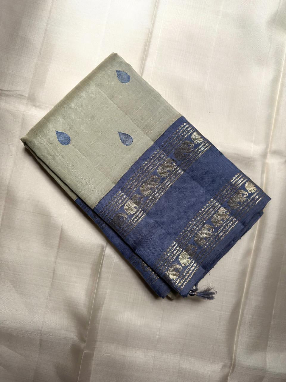 Navy teardrop motif detail on sage green silk