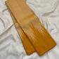 Traditional Thazampoo Reku Korvai border with elongated sandalwood-ivory triangular forms against golden mustard silk.