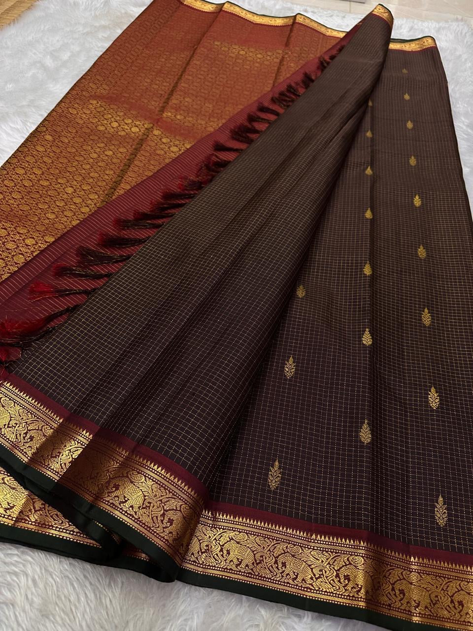 Folded deep brown pure silk Kanchipuram saree with maroon and green contrast border