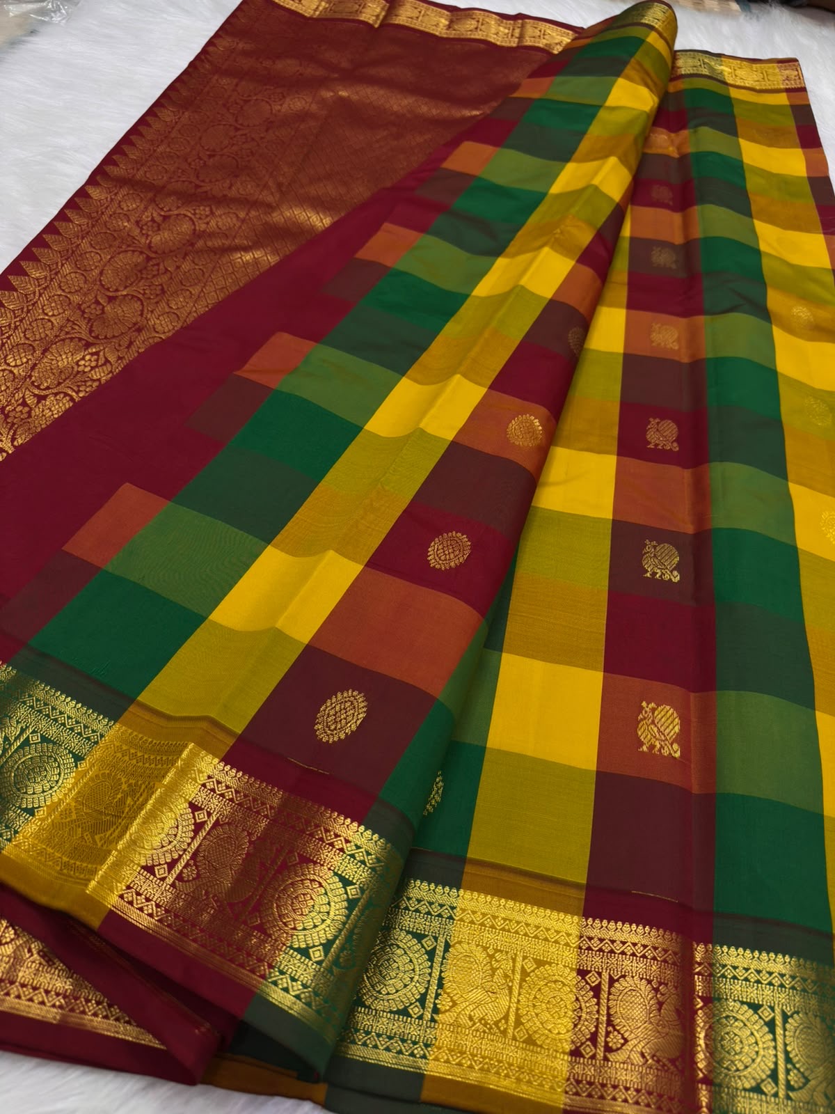 Close-up of Paalum Pazhamum jewel-tone checks on Kancheepuram silk saree body