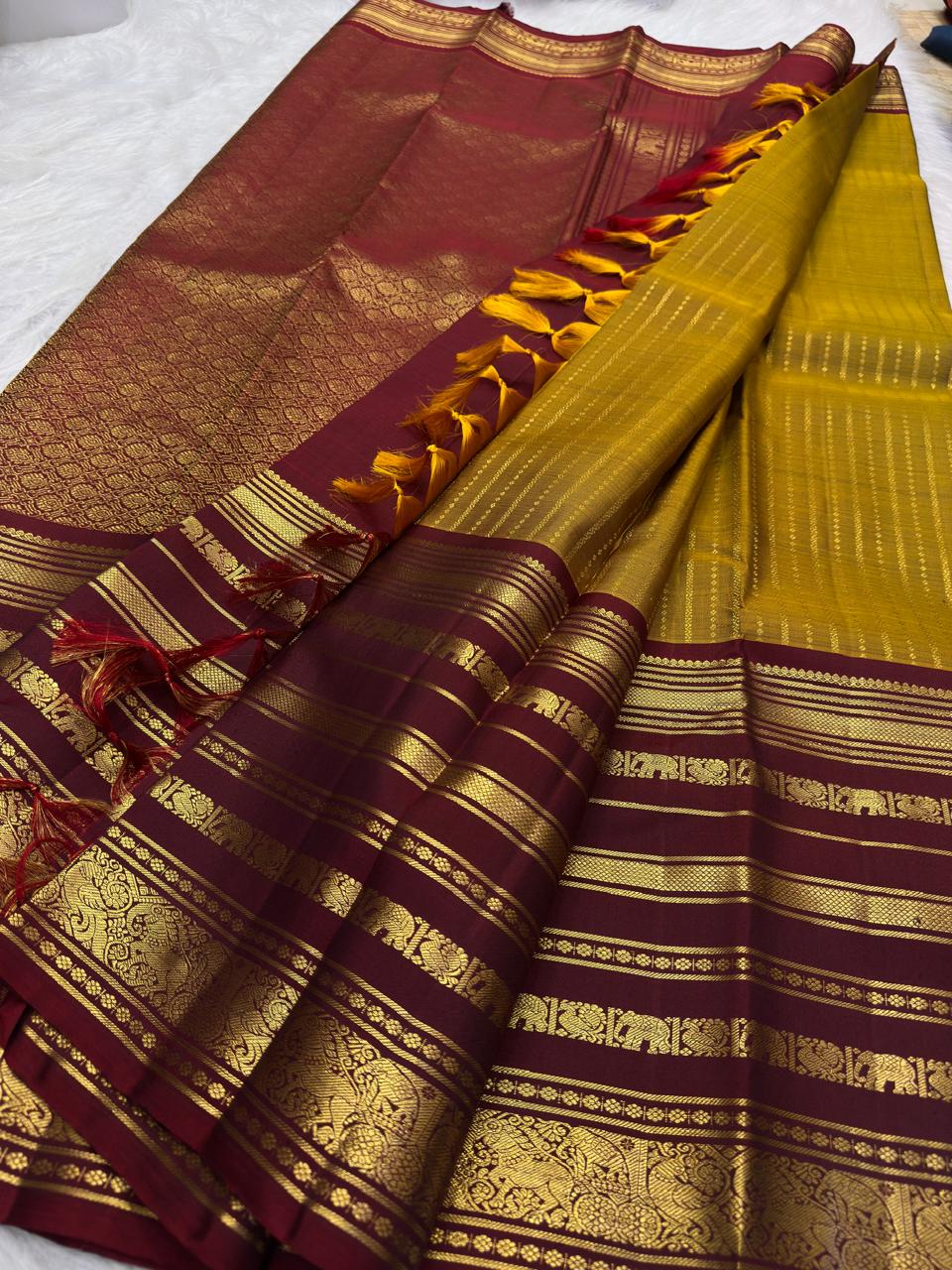 Turmeric yellow silk body with closely arranged oosivaanam gold zari lines