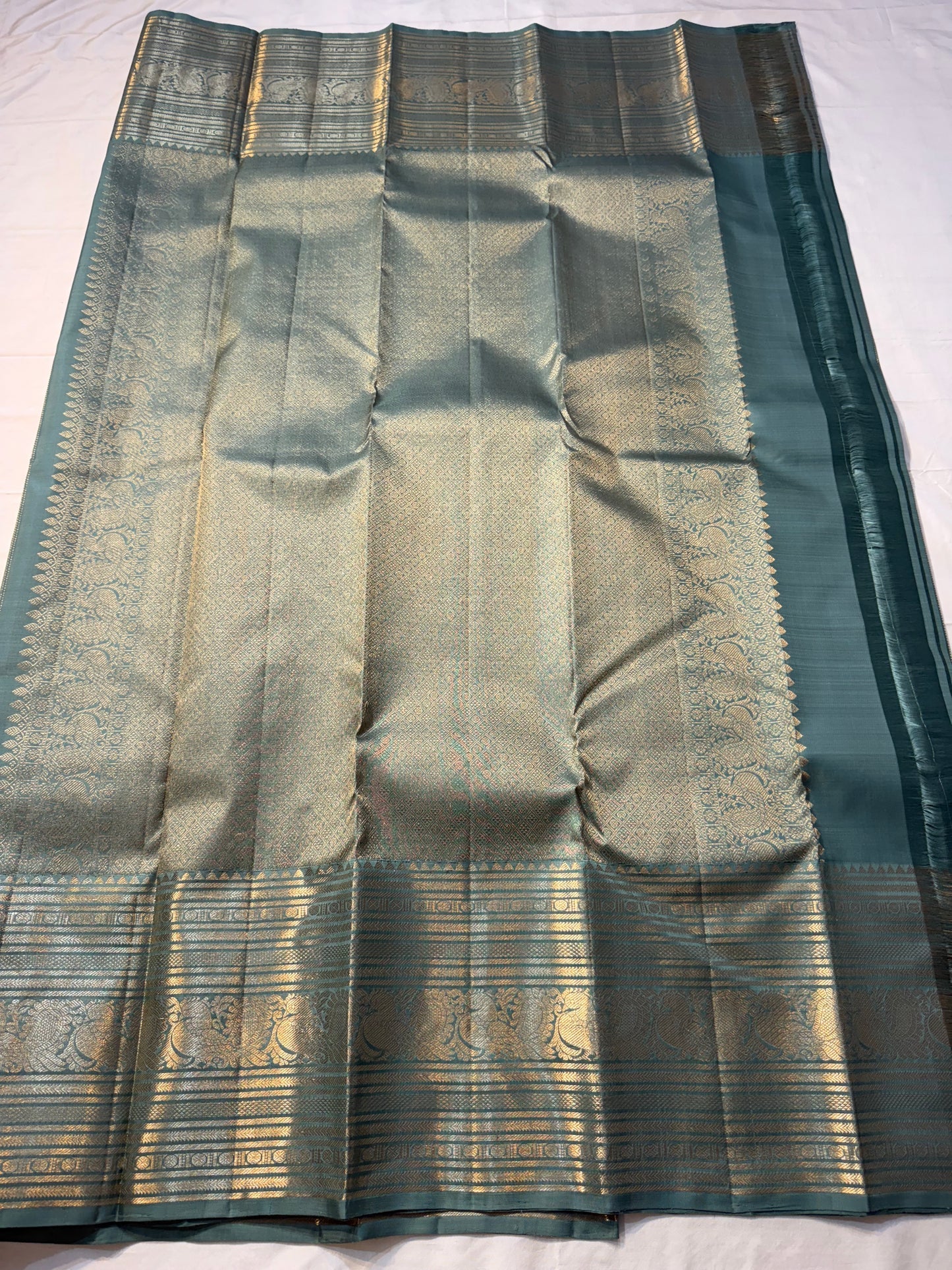 Muted sea-jade/duck-egg green body with fine oosi (pin) stripes

All-over tiny rosette/coin buttas for a soft shimmer

Silk Mark Certified | Free Shipping within USA | Ships in Two Weeks. Blouse Stitching ($30)
