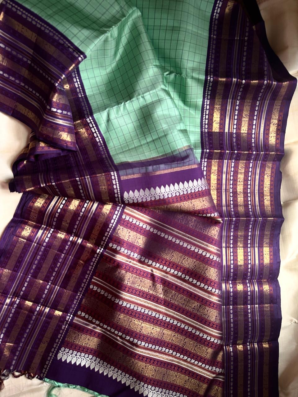 Sage Glory – Mint Green & Purple Kanchipuram Silk Saree ✨
Elegant Kattam Checks with Grand 3g zari Korvai Border
Rich Purple Pallu Woven with Traditional Motifs
Coordinated Blouse Piece with Matching Zari Finish

Silk Mark Certified, delivery in 2 weeks