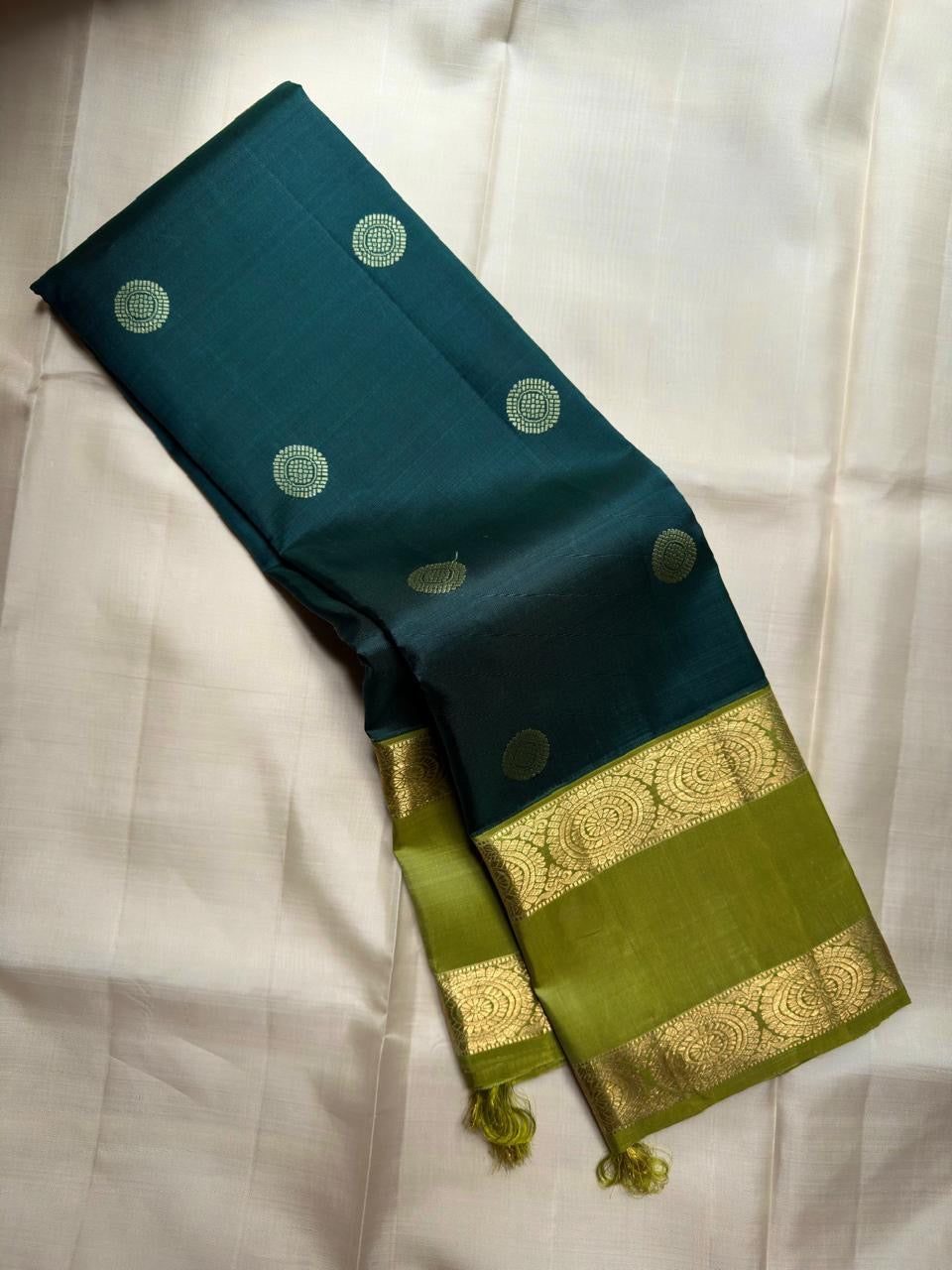Olive green rettapet border detail on peacock teal saree