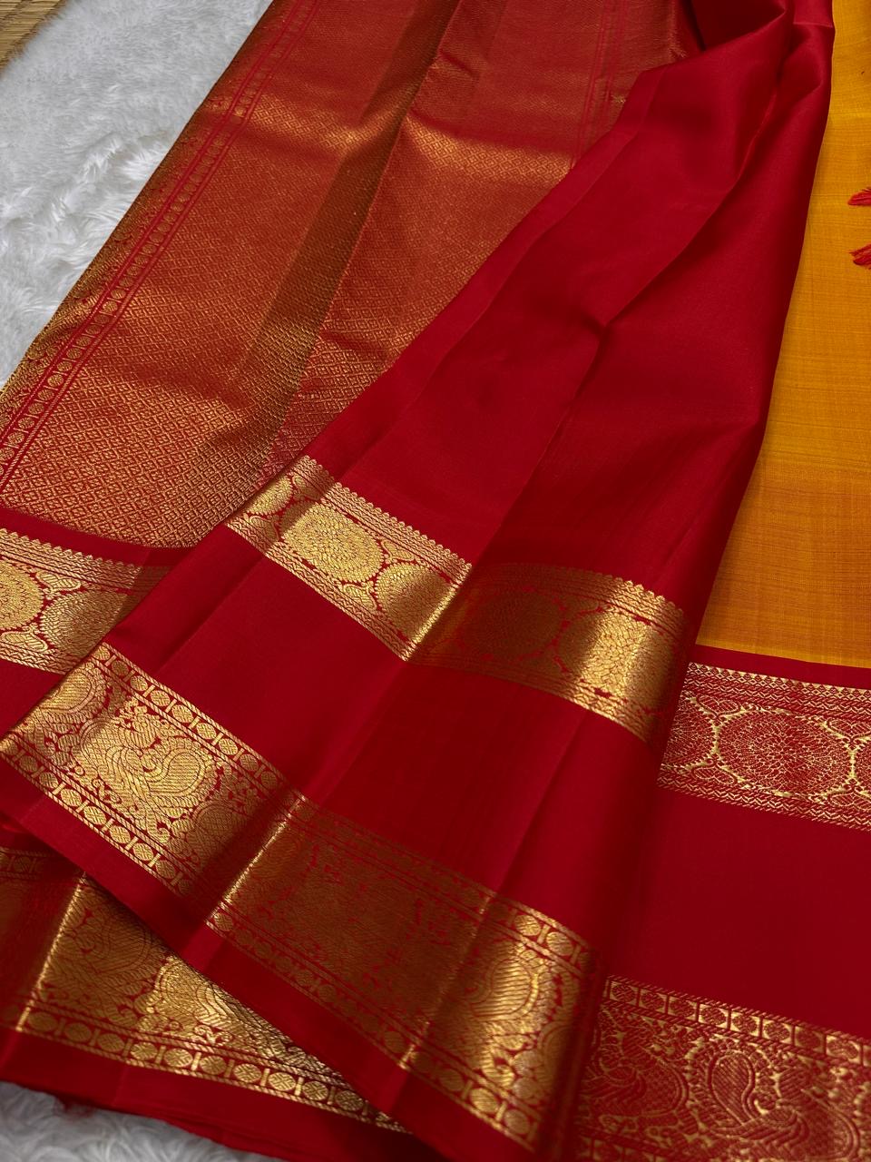 Mustard Kanchipuram silk saree with delicate gold zari buttis and red pallu