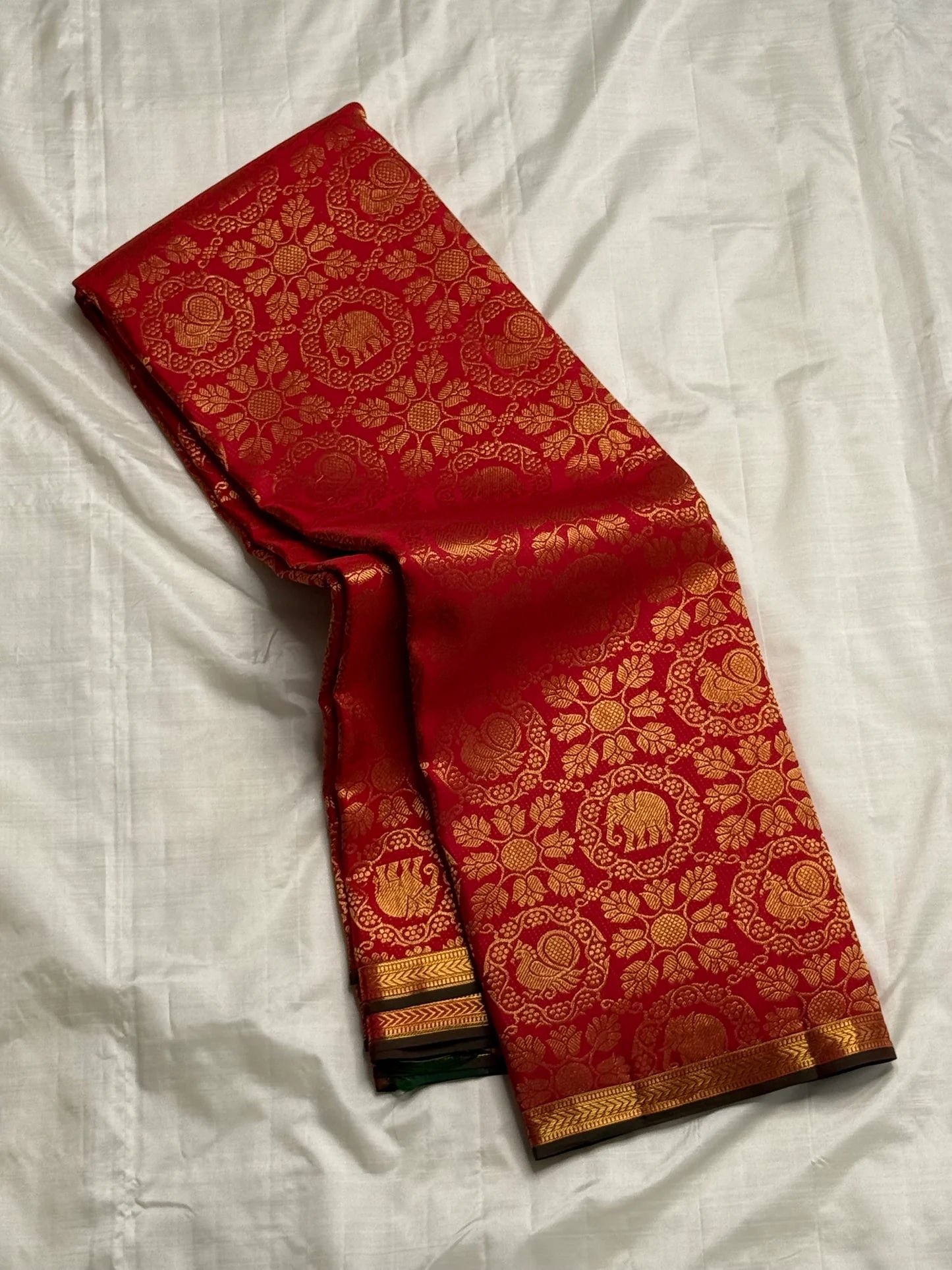 Sindhoor Padma Chakram — Pure Kanchipuram Silk Saree
Sindoor red body with lotus chakram jaal of elephants & paisleys, antique-gold border with green selvedge ✨
Grand brocade pallu & contrast emerald blouse • Silk Mark Certified • Free Shipping within USA
