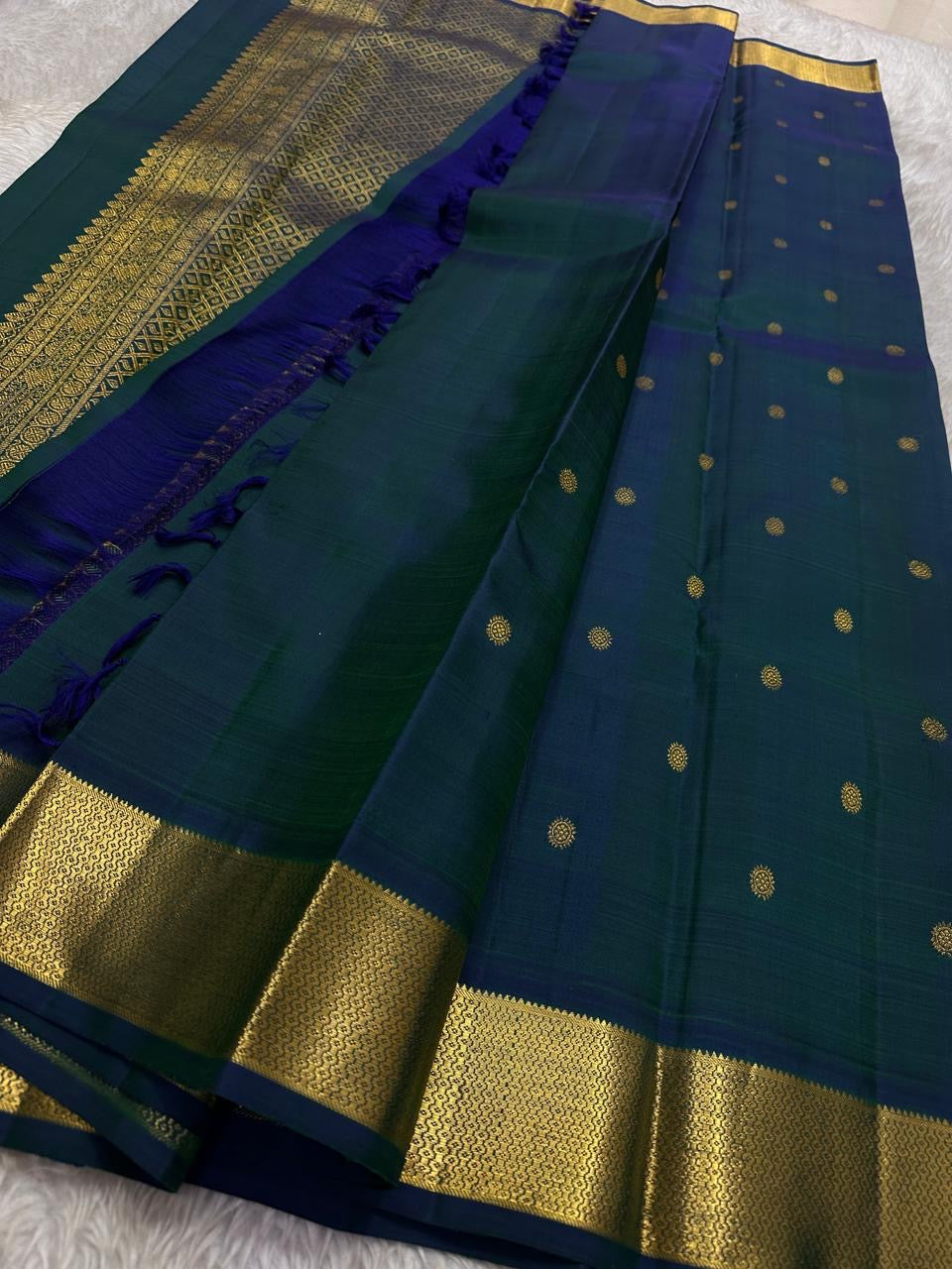Full saree view showing teal body with gold buttas, deep blue accents, zari woven border and rich zari pallu with tassels