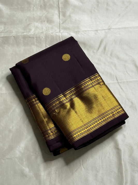 Nagavalli – A Midnight Jamun Dream in Kanchipuram Silk, Woven with Gold Coin Buttas, Temple-Inspired Arai Maadam Border, and Rudhraksham Seer in Lustrous Zari