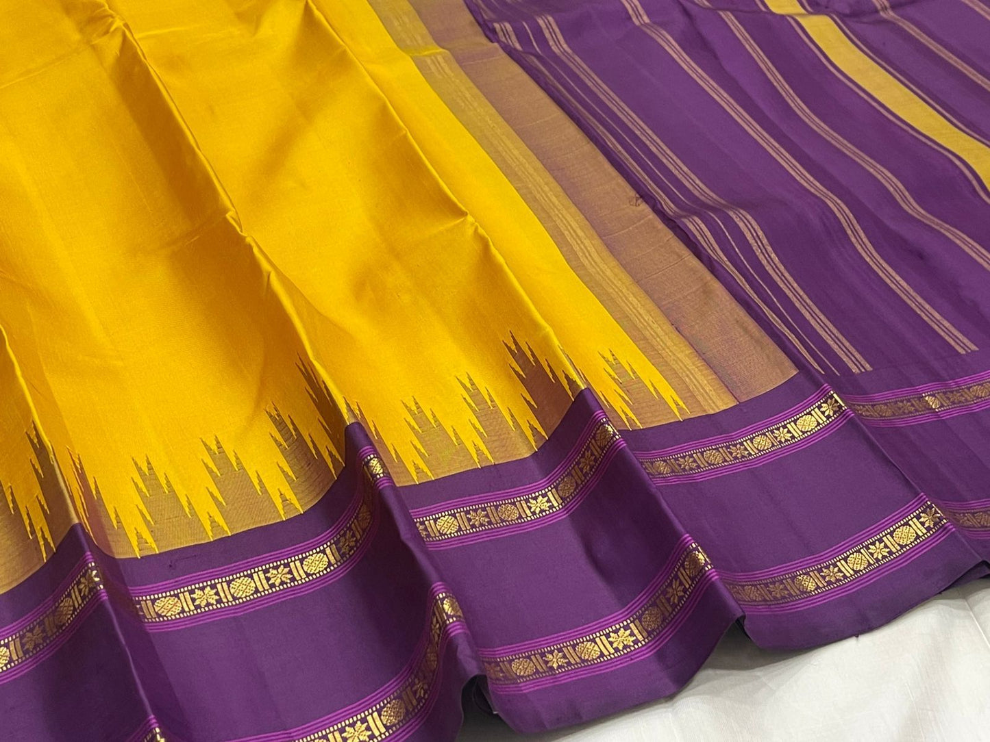 Suvarna Nitya
Mustard–Purple Kanchipuram Silk Saree
Heritage Temple Reku • Gold Zari Borders • Silk Mark Certified