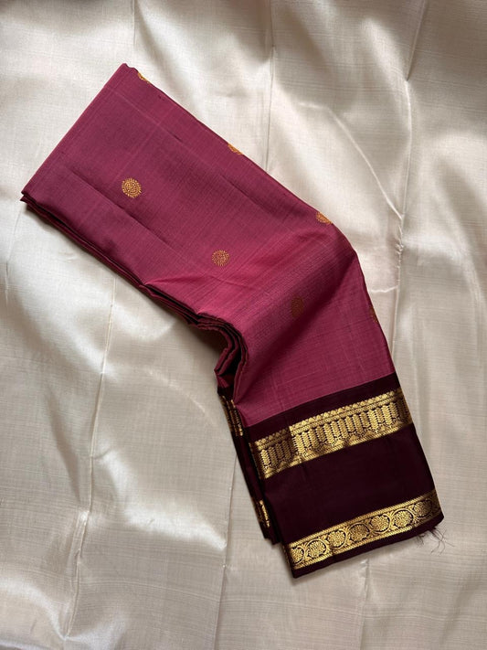 Maroon silk saree drape showing contrast coffee border with gold zari woven bands