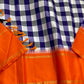 Indigo–Tangerine Checkmate — Pure Silk Kanchipuram
Bold indigo–lilac–white buffalo checks with ash accents ✨
Vibrant tangerine korvai border with temple (reku) teeth 🌸
Solid tangerine pallu with fine thread stripes & tassels 🪔
Silk Mark Certified •
