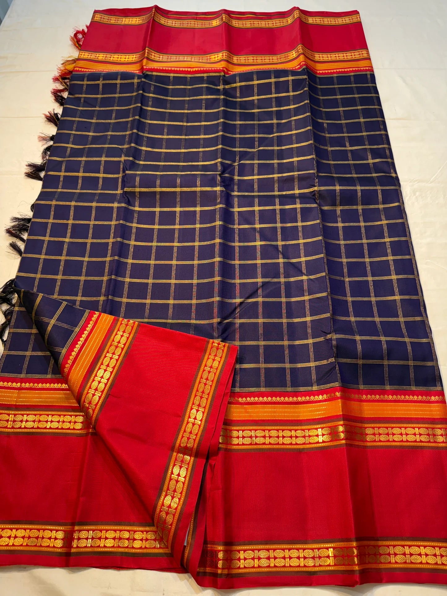 Rani Maragatham Zari Kattam — Pure Silk Kanchipuram (Handloom)
Purple  body with fine gold kattam checks & zari lines • Vibrant vermillion red border with temple coin motifs
Rich red  pallu with antique-gold zari panels • Silk Mark Certified ✅