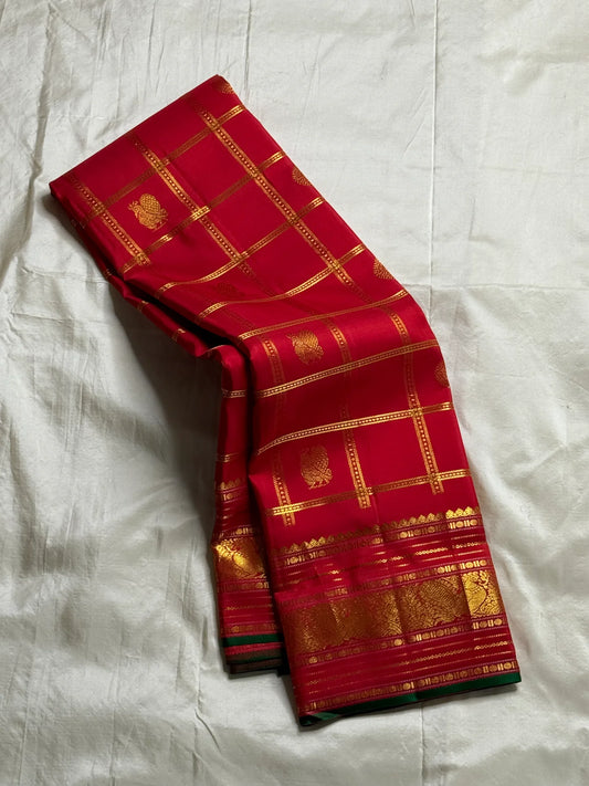 Ravi Kiranam — Sona Roopa Kattam Kanchipuram Pure Silk

Vibrant festive red body with allover kattam (grid) checks

Gold & silver sona-roopa zari alternating for a soft shimmer

Grand kaddi border with rich zari paisley vines & floral tracery

Silk Mark