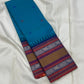Peacock-teal body with woven silk-thread buttas in navy & coral hues
Korvai contrast ruby-maroon borders with gaja-chakram & temple motifs
Grand varisaipettu striped pallu in navy, mustard & maroon tones
Silk Mark Certified • Ships in Two Weeks