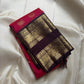 A regal  shot tomato red pink Kanchipuram silk saree features elegant chakram and mayil gold zari buttas woven across the body. Brown contrast rettapet border and Pallu vanasringaram details