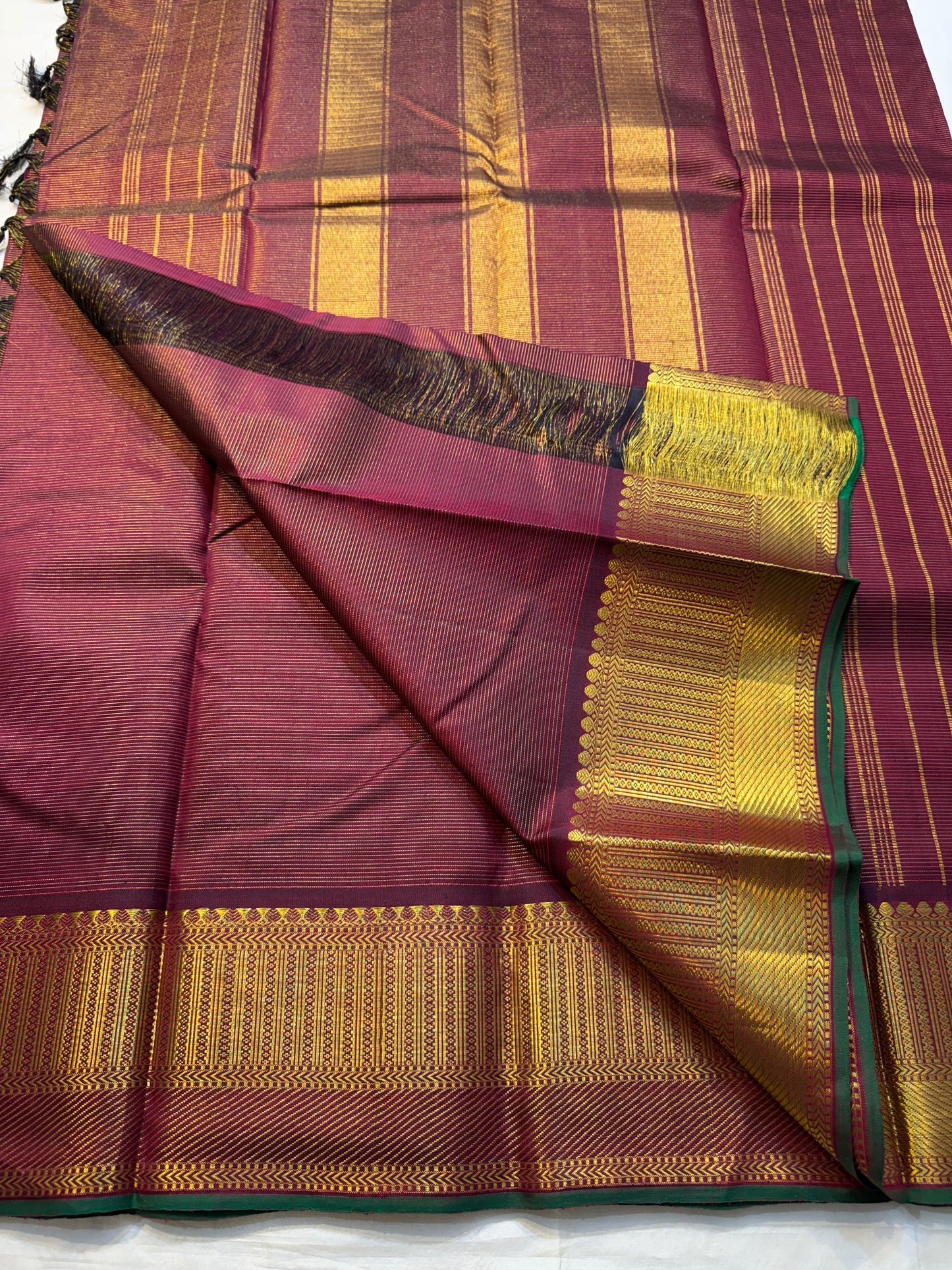 Shyama Vairaoosi — Pure Silk Kanchipuram

Deep Shyama brown with micro Vairaoosi pinstripes

Temple-column antique gold zari border, bottle-green selvedge

 Grand striped zari pallu with hand-tied tassels

Silk Mark Certified • free shipping