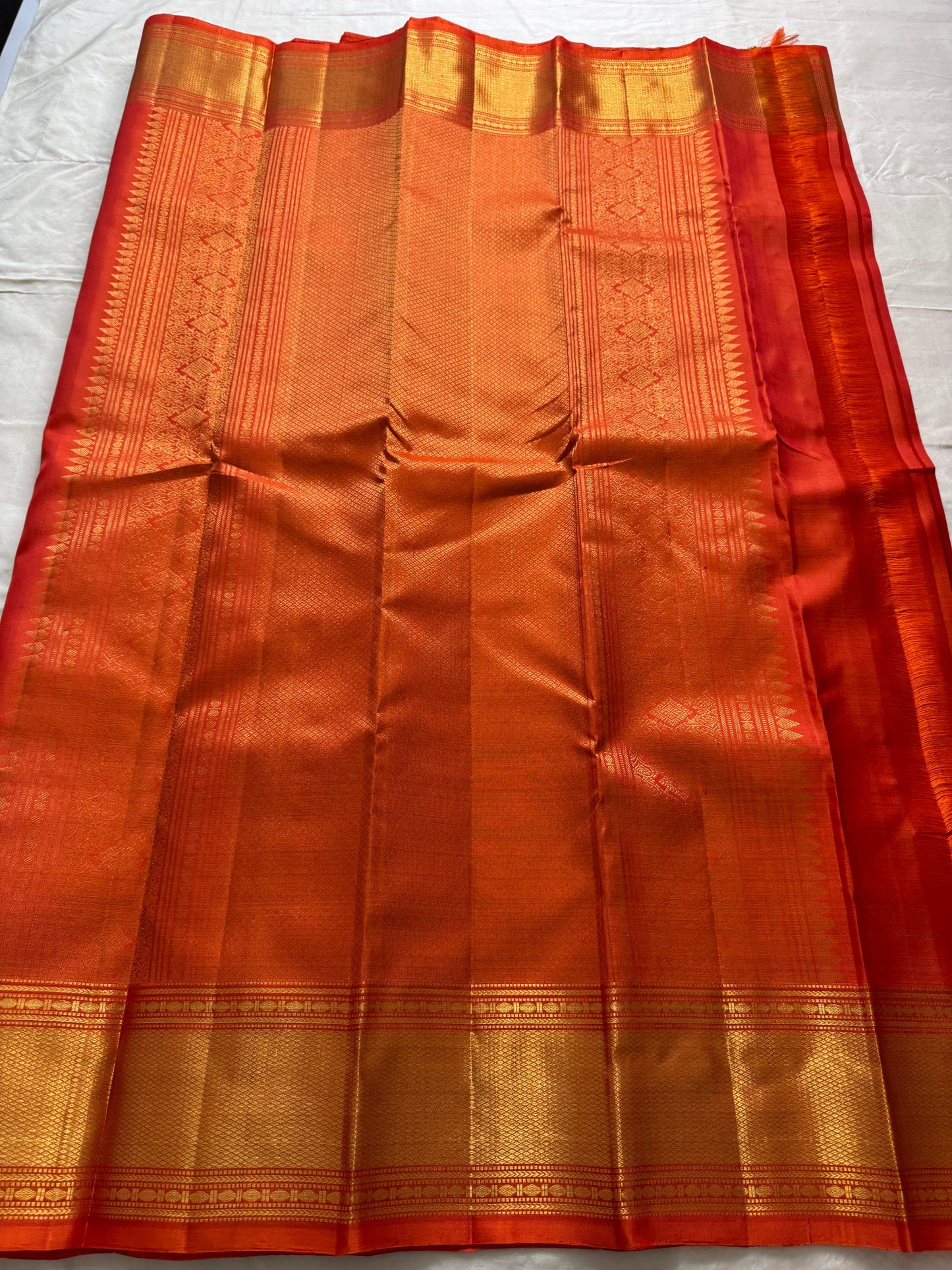 Maya
Vibrant Orange Kanchipuram Silk Saree with Lustrous Gold Coin Buttas
Handwoven Traditional Rudhraksham Seer and Intricate Arai Maadam Zari Border
Richly Crafted Pallu Featuring Elegant Gold Zari Panels for a Regal Finish