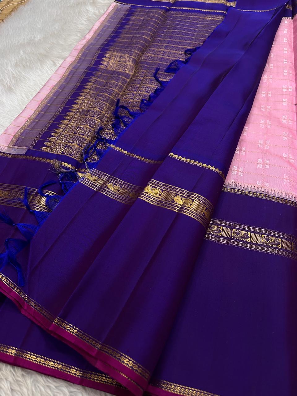 Anaar ✨ – Royal Purple & Lotus Pink Kanchipuram Pure Silk Saree
With Zari Kattam Checks, Mayil Motif Border & Grand Pallu
Korvai Contrast Weave in Regal Purple , 
Peacock & Floral Zari Panels, Raspberry Selvedge Finish
Silk Mark Certified