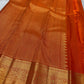 Red Kanchipuram silk saree with gold peacock buttas and traditional gold zari border shown fully opened.