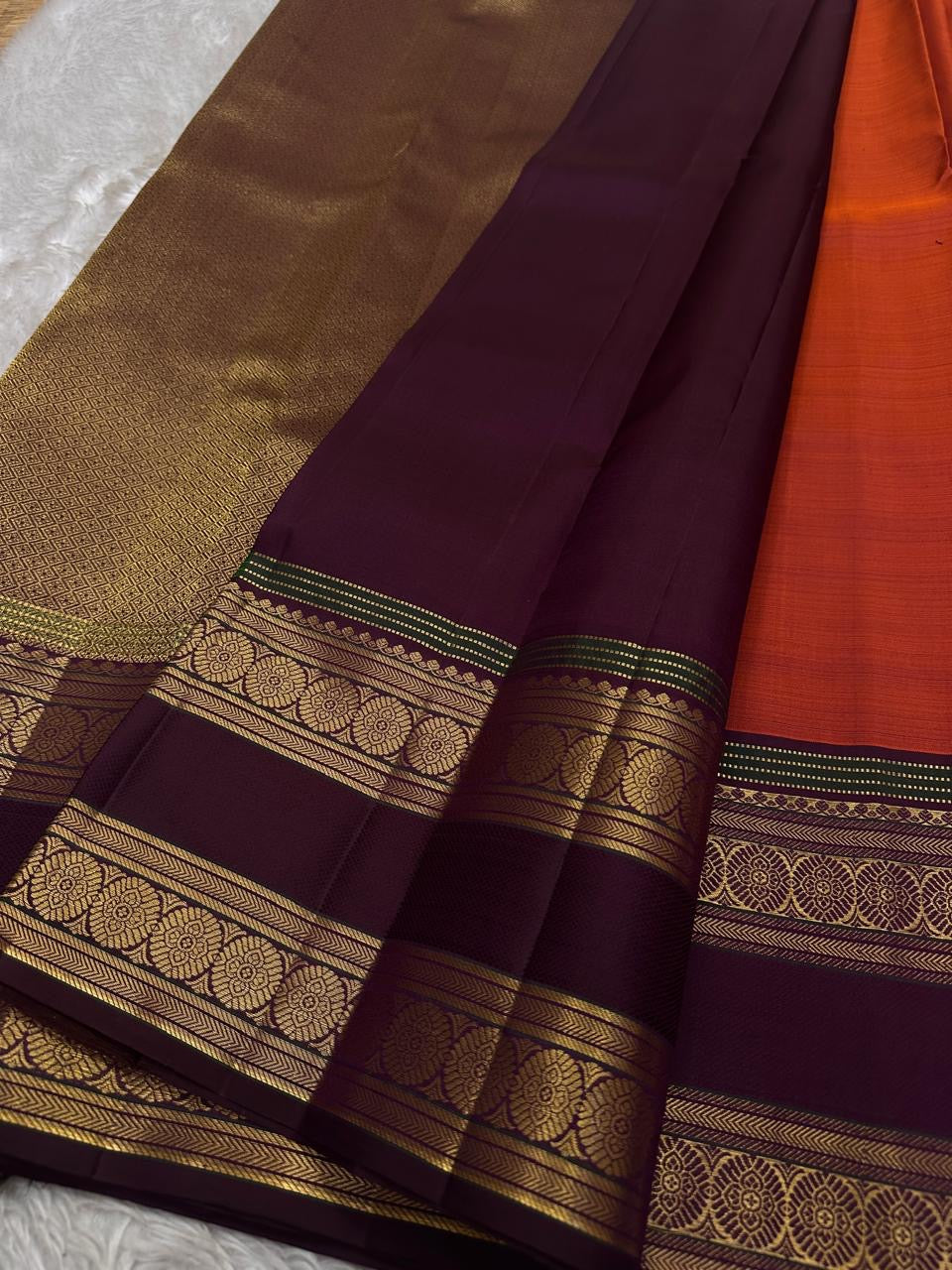 Ishwaryam 🧡❤️🕊️✨
Orange Red Shot Handwoven Kanchipuram Silk Saree with Majestic Gandaberunda Zari Adai Motif 🕊️🌟
Ornate Rettapet Border with Delicate Kamalam Seer Floral Detailing 🌺🪡
Deep Coffee Brown Pallu Adding Warmth and Elegant Contrast ☕🌿
