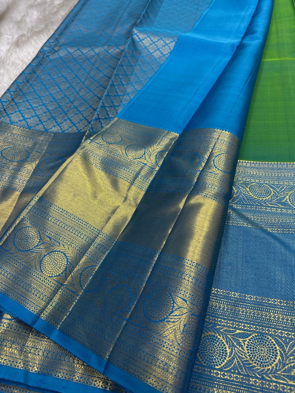 Parrot green Kanchipuram silk saree with gold zari coin buttas, contrast sky blue zari border and pallu