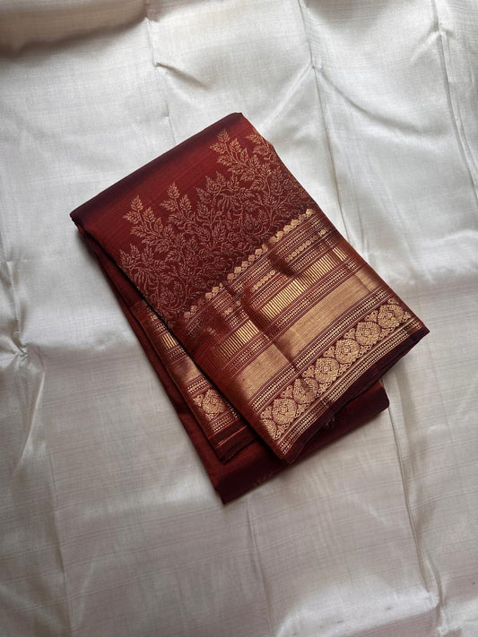 Gilded Rust – Pure Kanchipuram Silk Saree
Deep rust body with delicate paisley zari buttas 🌿
Antique-gold border featuring kaddi stripes & floral motifs ✨
Grand brocade pallu with lattice jaal & floral vines 🕊️

Silk Mark Certified, delivery in 2 weeks
