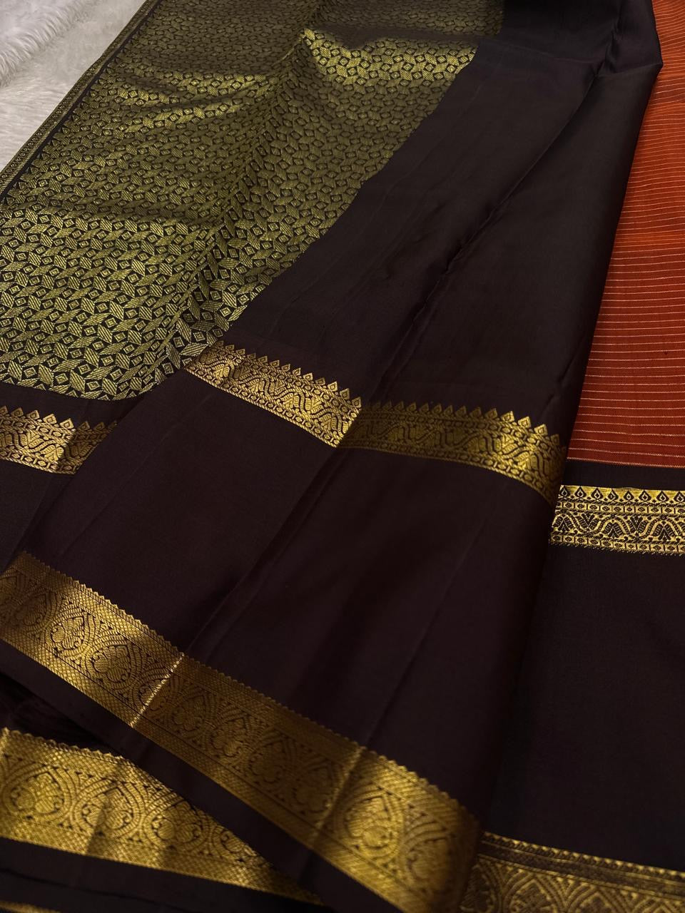 Gilded Rust Kattam – Pure Silk Kanchipuram Saree

Rust-orange kattam (checks) body with petite zari buttas ✨
Deep brown  korvai border with intricate gold zari design 🌸
Grand zari-rich pallu 💛
Silk Mark Certified ✅ | ships in two weeks