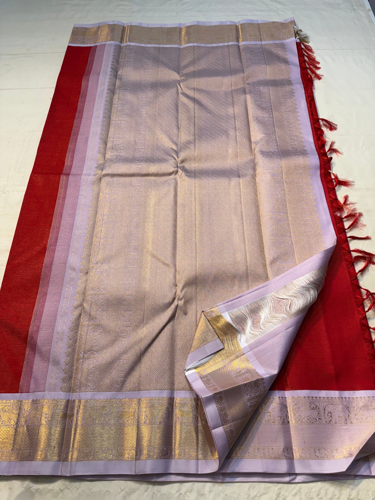 Scarlet Lilac Vairaoosi – Pure Kanchipuram Silk
Scarlet body • Lilac korvai • elephant reku zari border • Brocade pallu
Silk Mark • Free USA Shipping • Ships in Two Weeks