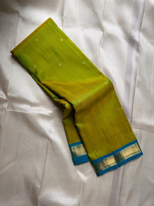 Citrus and Teal – Pure Kanchipuram Silk Saree
Dual-tone body in parrot green and turmeric.
Elegant gold leaf buttas across the drape.
Teal korvai border
Rich teal pallu with diamond jaal and temple motifs.

Silk Mark Certified, delivery in 2 weeks