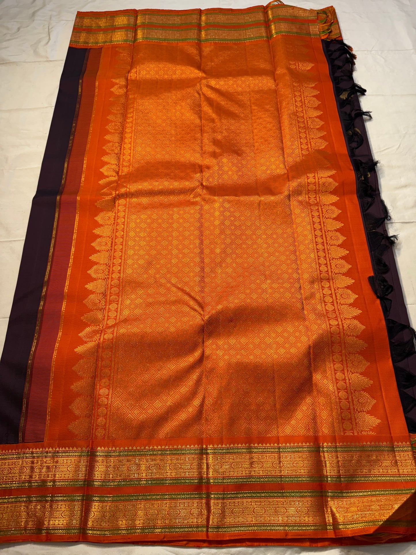 Deep Cocoa Manjari — Pure Kanchipuram Silk Saree
Rich cocoa-aubergine body with antique-gold manjari buttas, paired with a radiant kavi-orange korvai border and green selvedge accent.
Silk Mark Certified • Blouse Stitching Available ($30) • Free Shipping