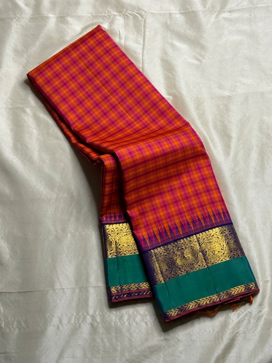 Chemman Maragatha Kattam
Pure Kanchipuram Silk Saree – Reddish-Orange & Maragatha Green Micro Checks
Deep violet korvai borders with gold zari floral motifs
Grand zari pallu with classic brocade detailing
Silk mark certified, ships in 2 weeks