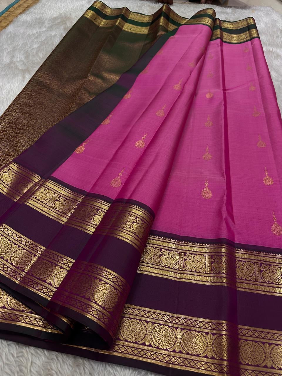 Anvitha – Magenta & Pink Shot Kanchipuram Pure Silk Saree
Glowing dual-tone silk body in radiant magenta and pink
Paired with a rich brown rettapet border featuring peacocks & floral vines in gold zari