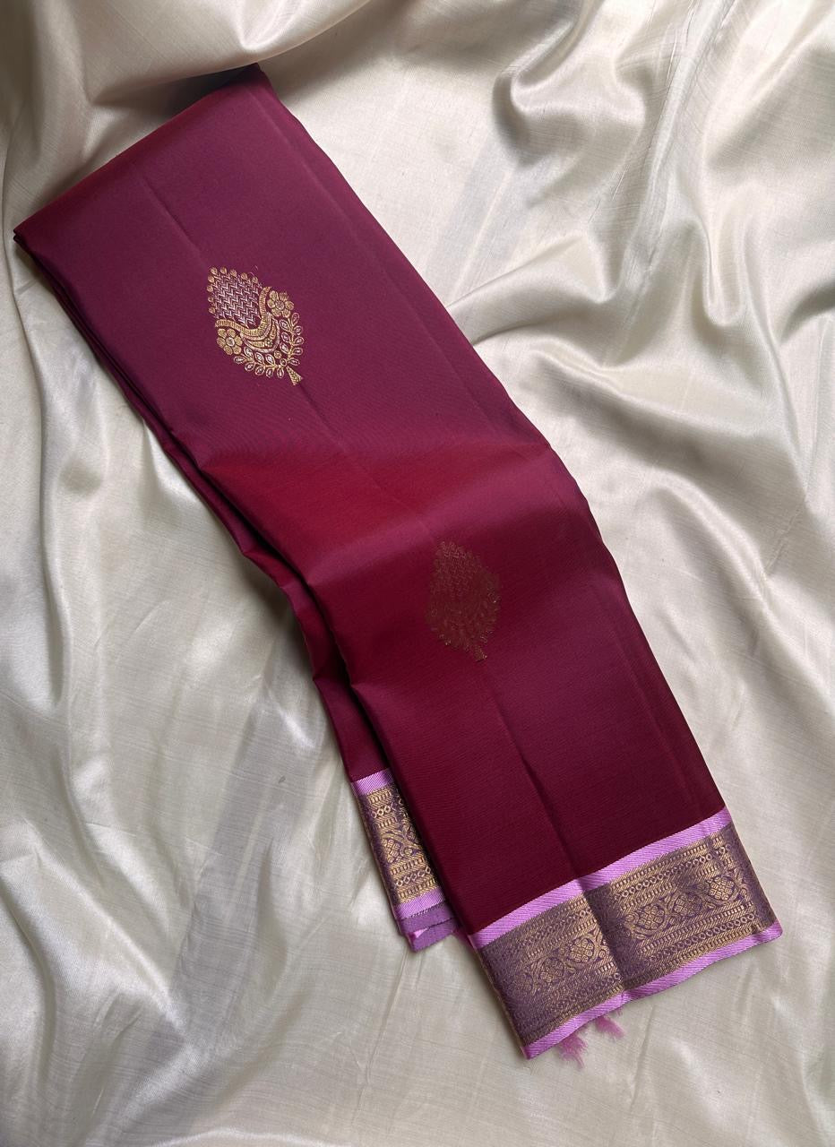 Deep maroon Kanchipuram saree with zari buttas and soft petal-pink pallu