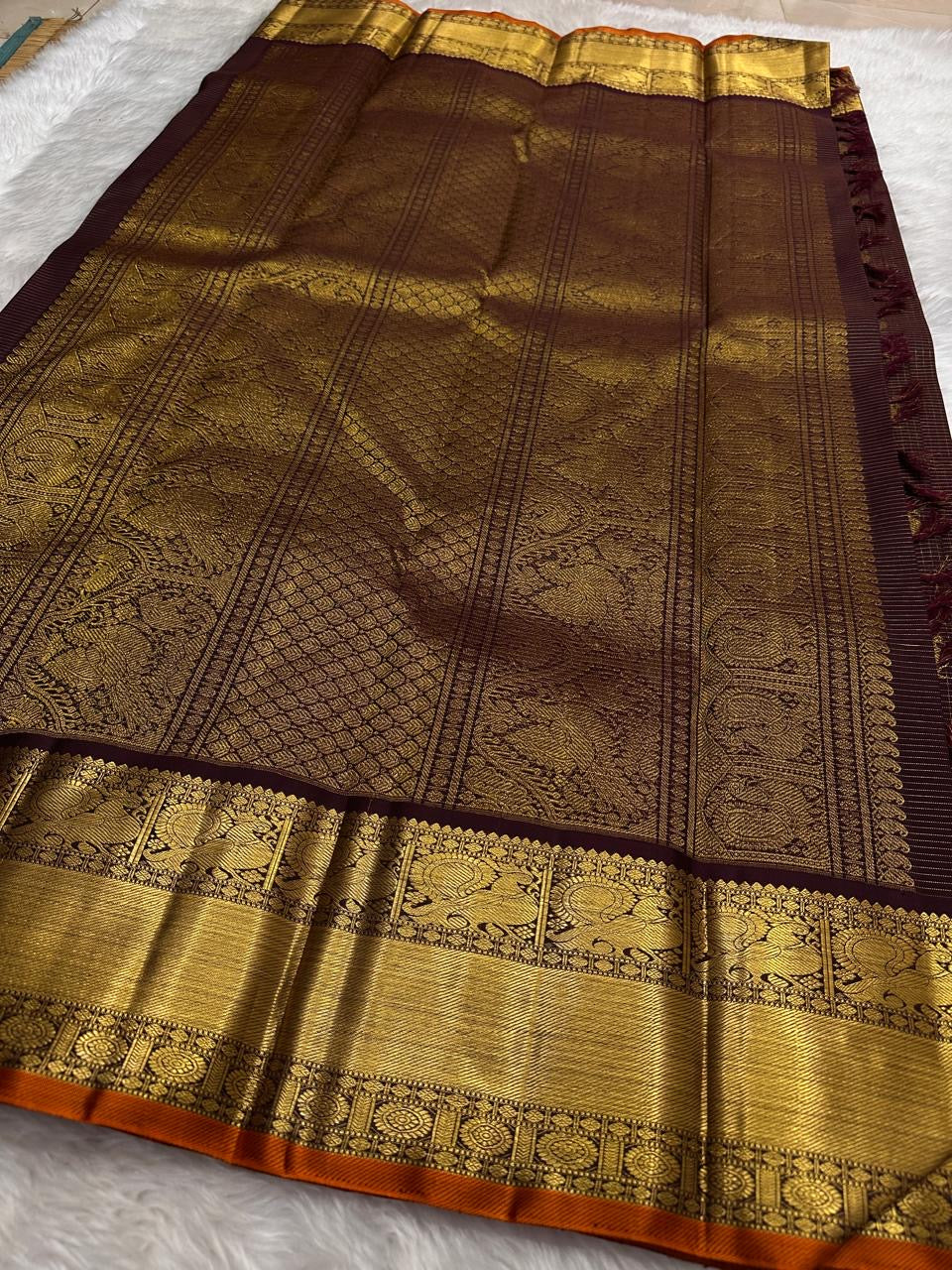 Deep brown Kanchipuram silk saree with orange selvedge and traditional zari weaving