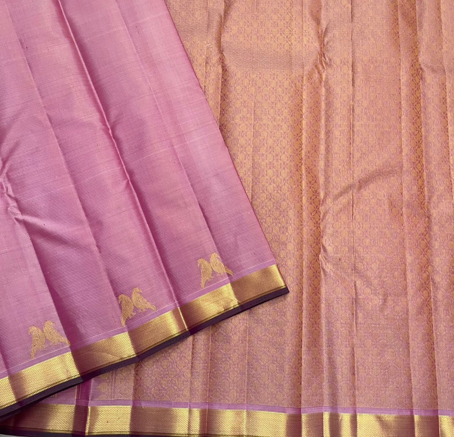 Traditional gold zari kili motifs on pastel pink Kanchipuram silk saree border