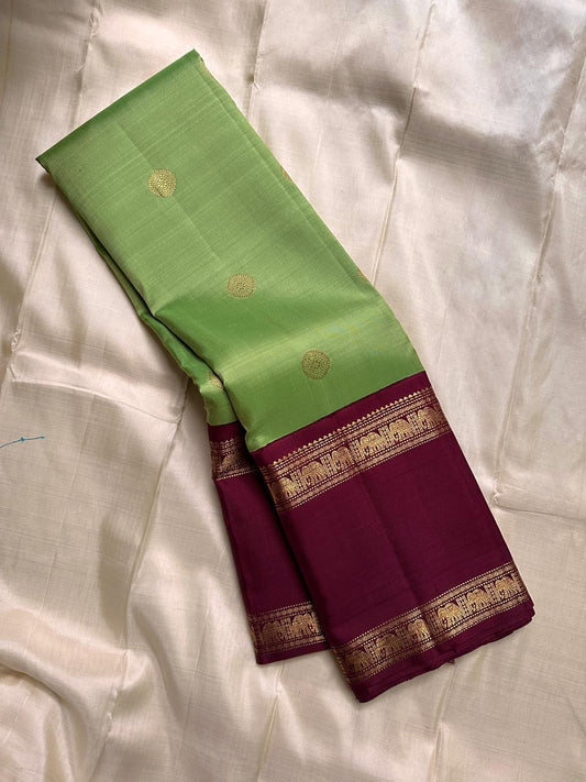 Samprada – Kanchipuram Silk Saree in vibrant cardamom Green & brown
A vibrant parrot green body meets a rich maroon border in this timeless Kanchipuram silk saree